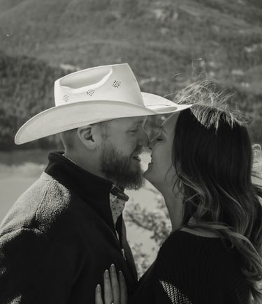 a man and woman kissing in a mountain