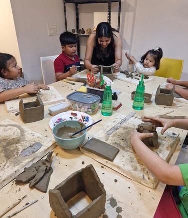 A pottery workshop where a teacher guides children in creating clay sculptures, enhancing fine motor skills and creativity.