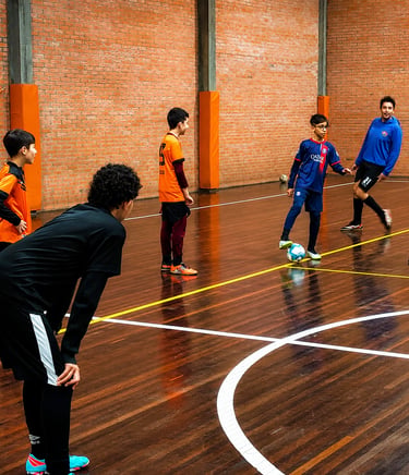 Alunos da escolinha de futsal treinando fundamentos em quadra coberta no Centro Poliesportivo Aviva,