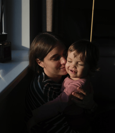 mother and toddler hugging with closed eyes in Geneva