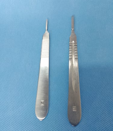 Dois cabos de bisturi (modelos 3 e 4) sobre tecido azul estéril, compatíveis com lâminas cirúrgicas