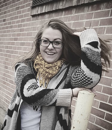 photo of sara dudenhoeffer dressed in a sweater and scarf, laughing