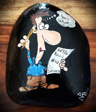 Cartoon painted on a rock of a man surveying a crazy address