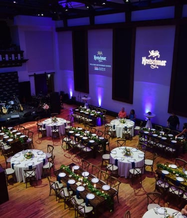 a large room with tables and chairs and a stage