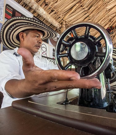 Un artisan portant un sombrero vueltiao utilise une machine à coudre vintage pour créer des chapeaux