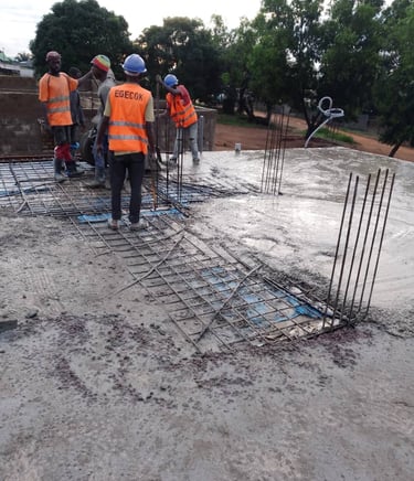 a group of men in safety vests working on a concrete slab