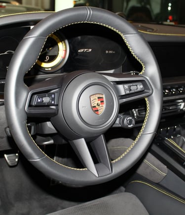 Porsche 911 GT3 steering wheel trimmed in black with "racing yellow" stitching