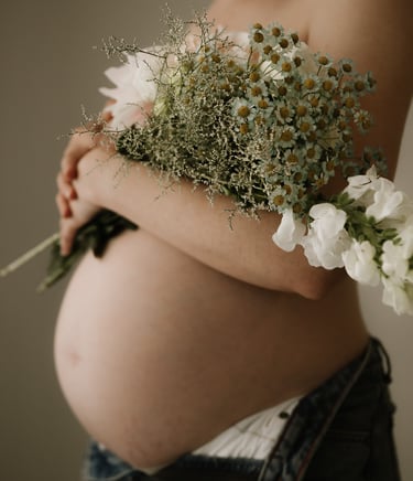 pregnant belly holding flowers taken in studio, Adelaide