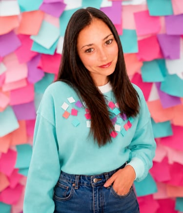 Créatrice au style coloré devant un mur de post-it, l'univers créatif de M.I.U.