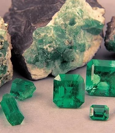Rough and polished green Colombian emeralds displayed for sale during an exclusive private shopping tour.