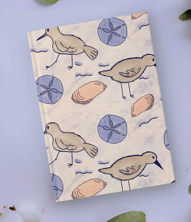 a notebook with a sand piper bird and seashells on it