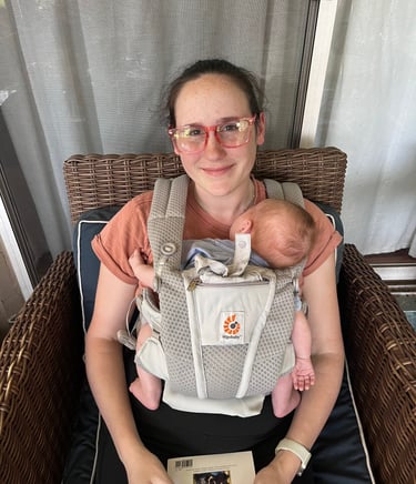 Mom wearing her newborn in an Ergo baby carrier.