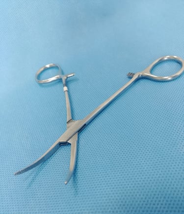 Pinça Kelly curva sobre tecido azul estéril, usada para pinçar vasos e tecidos.