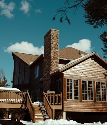 a house with a wooden deck and tall chimney