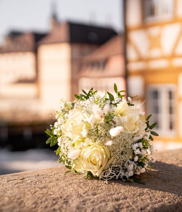 a bouquet of white flowers on a stone wall