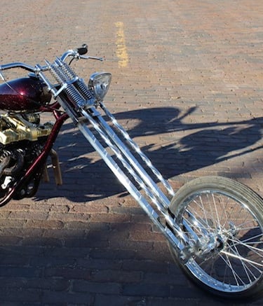 custom motorcycle parked on a brick road