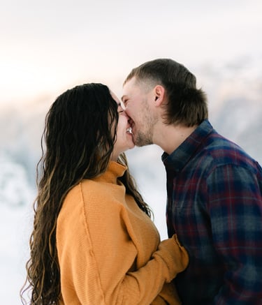 a man and woman kissing in the snow