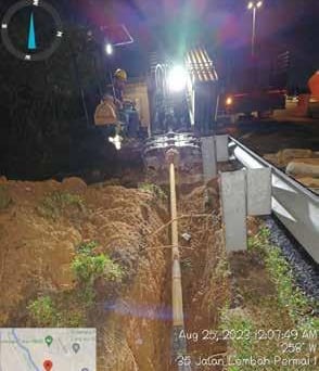 a construction site with a construction worker on the side of the road