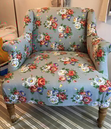 Fauteuil confortable de style anglais recouvert de tissu bleu à motif floral blanc et rouge