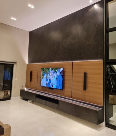 Sala de estar moderna com TV fixada na parede em um painel MDF madeirado e MDF que imita mármore