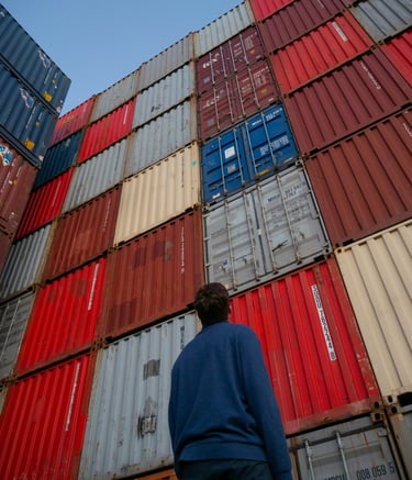 a man standing in front of a large stack of containers