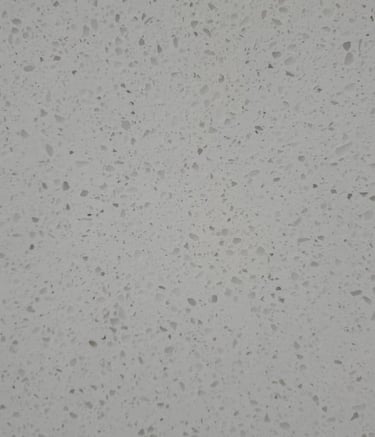 Close-up of light gray quartz slab with speckled texture