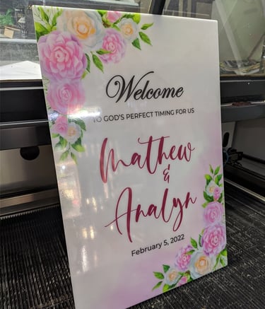 Acrylic wedding sign with floral design and text.