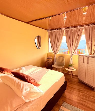 Habitación sencilla con cama doble, ventana con vista a la montaña