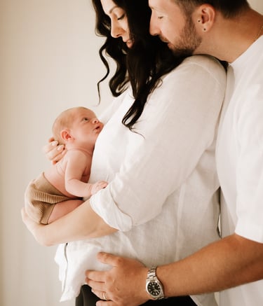 couple holding newborn baby where baby bump was, in studio Adelaide Hills 