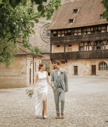 a bride and groom walking down a cobblestone path