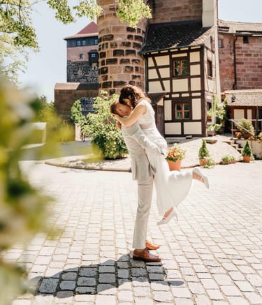 a bride and groom are kissing in front of a large building
