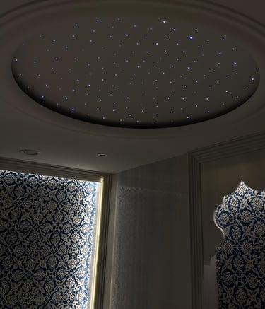 Luxury interior with a circular fiber optic star ceiling and blue patterned Arabic wall art.