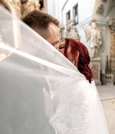 a bride and groom are kissing in a church