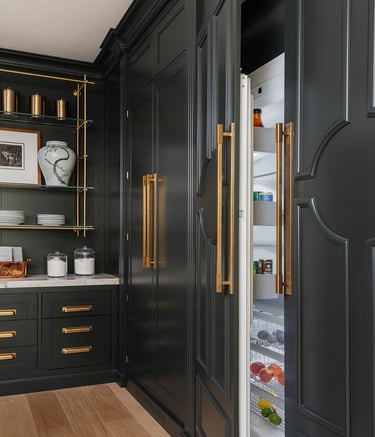 a kitchen with black cabinets and gold accents