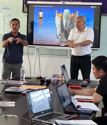 a group of people sitting around a table with laptops