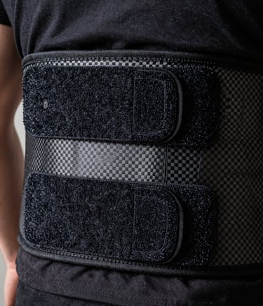 Close-up photography of a technical lumbar support belt showing high-grade Velcro and carbon fiber textures, soft hangar lighting, masculine and industrial feel, North American / International context.