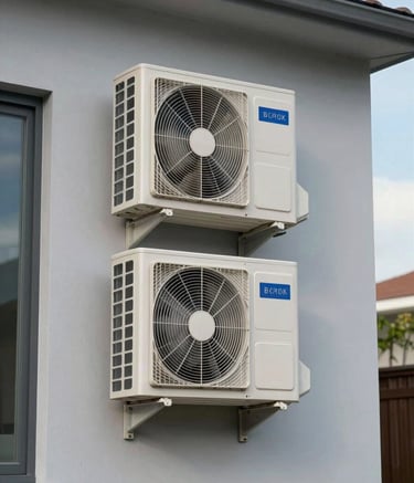 Photography of a modern South American home exterior with a neatly installed external air conditioning condenser unit. The setting is clean, with light gray walls and clear blue sky, reflecting efficiency and professional installation.