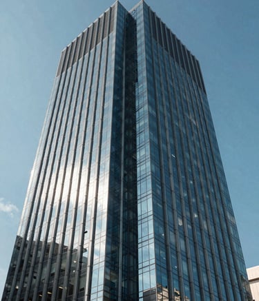 The exterior of a modern South American business tower with reflective glass panels under a clear blue sky, symbolizing innovation and reliability, with Steel Blue architectural details.