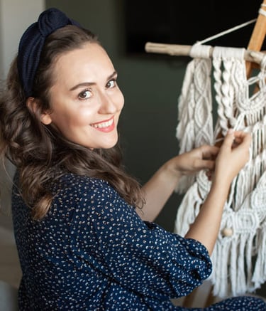 mujer sonriente tejiendo macramé