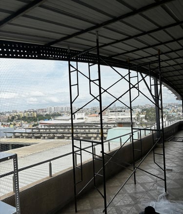 Wide shot of a residential building balcony fitted with safety nets by Arjilli Enterprises.