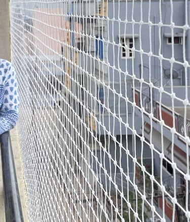 Close-up of a sturdy pigeon net installed on a balcony railing with sunlight filtering through.