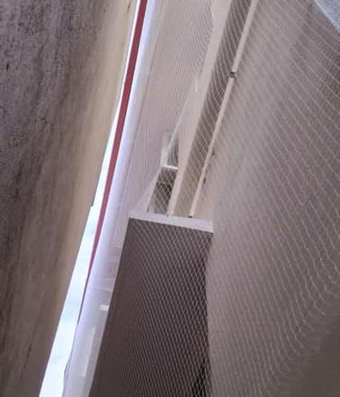 Installation team fitting pigeon nets on a residential window in Hongasandra.