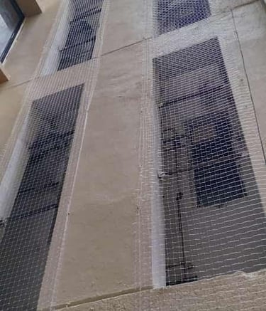 Wide shot of an apartment balcony fully covered with pigeon netting.