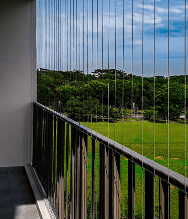 Close-up of a sleek invisible grill installed on a T Nagar balcony, blending seamlessly with the sur