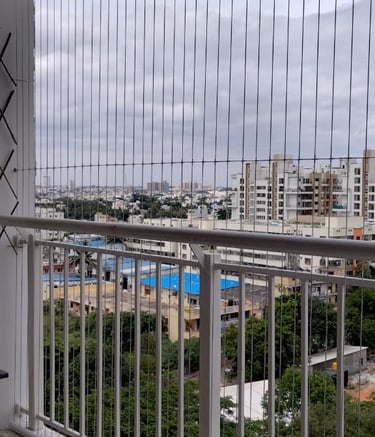 Close-up of a sleek invisible grill installed on a T Nagar balcony, blending seamlessly with the sur