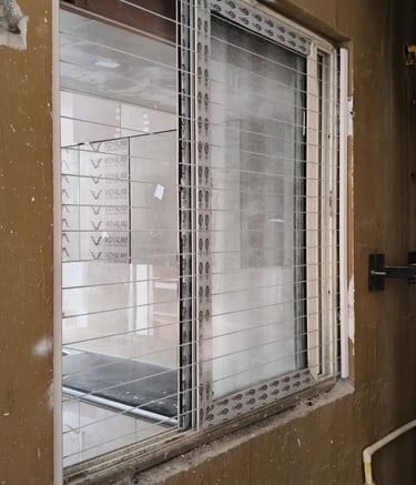 Installation team from Arjilli Enterprises fitting invisible grills on a Royapettah home.