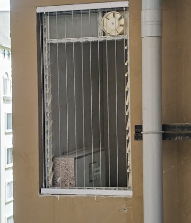 Wide shot of a modern apartment balcony featuring invisible grills with a cityscape backdrop.