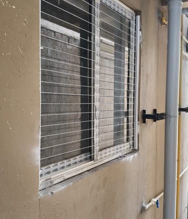 Wide shot of a modern apartment window featuring invisible grills by Arjilli Enterprises.