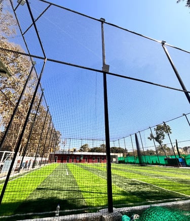 Football nets installed on a sunny terrace with cityscape in the background.