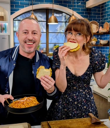 Dan Clapson eating Heated Rivalry inspired tuna melts with Mary Berg on The Good Stuff